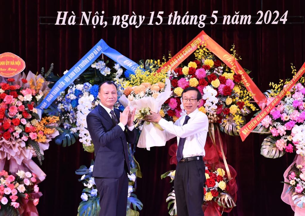PGS.TS. Nguyễn Đức Sơn tặng hoa cảm ơn GS.TS Nguyễn Văn Minh, nguyên Hiệu trưởng nhà trường.