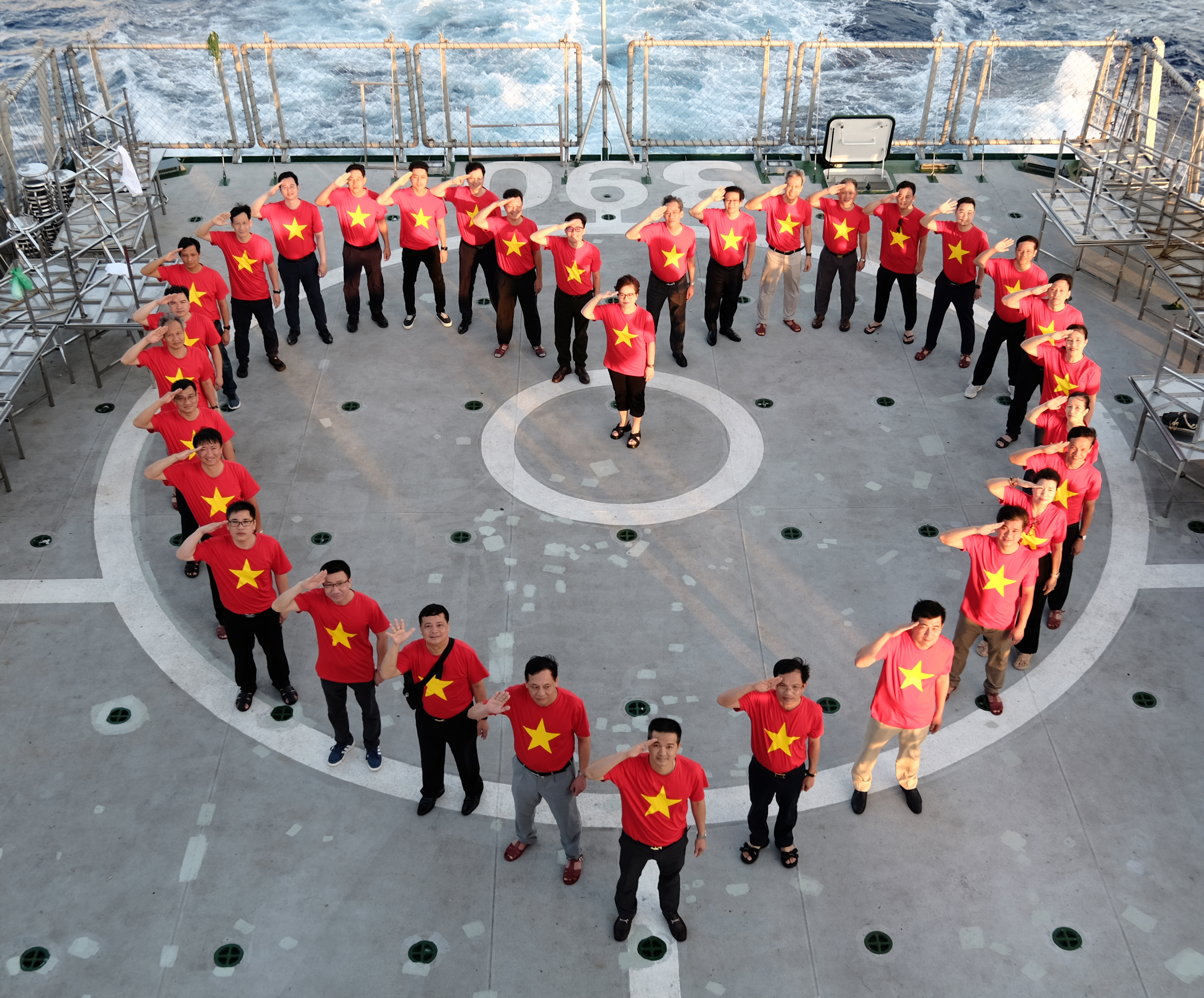 Đoàn công tác cùng nhau xếp hình trái tim trên khu vực sân bay của tàu Kiểm ngư KN390.