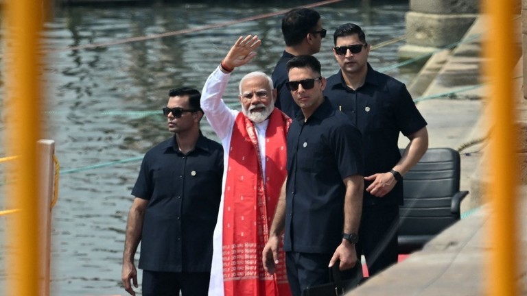 Thủ tướng Ấn Độ Narendra Modi (giữa) vẫy tay sau khi cầu nguyện bên bờ sông Hằng ở Varanasi ngày 14/5. (Ảnh: AFP)
