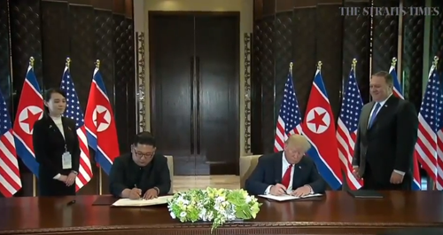 Nhà lãnh đạo Triều Tiên và Tổng Thống Mỹ ký thỏa thuận. Ảnh: Cắt từ video clip của The Straits Times
