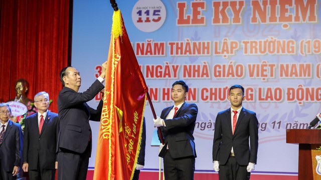 Chủ tịch nước Trần Đại Quang gắn Huân chương Lao động hạng Nhất lên lá cờ truyền thống của trường