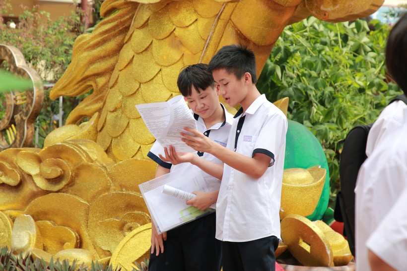 2 thí sinh tại điểm thi Trường THPT Lê Quý Đôn tranh thủ trao đổi lại đề thi. (Ảnh: TT)
