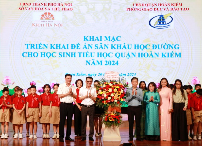Đại diện ngành GD-ĐT quận Hoàn Kiếm và các em học sinh tặng hoa chúc mừng các nghệ sĩ.