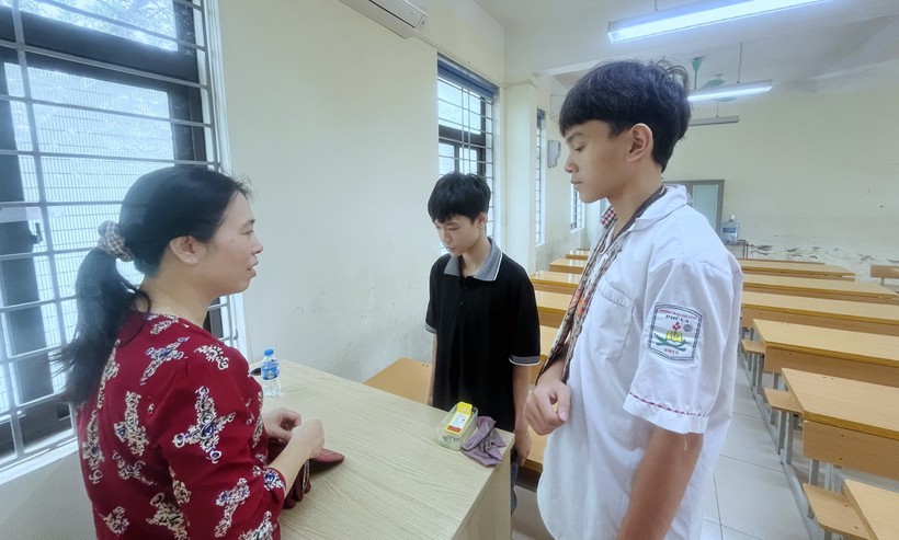 Cán bộ coi thi gặp gỡ, động viên thí sinh diện đặc biệt và học sinh hỗ trợ chép bài tại điểm thi Trường THCS Yên Nghĩa (quận Hà Đông).