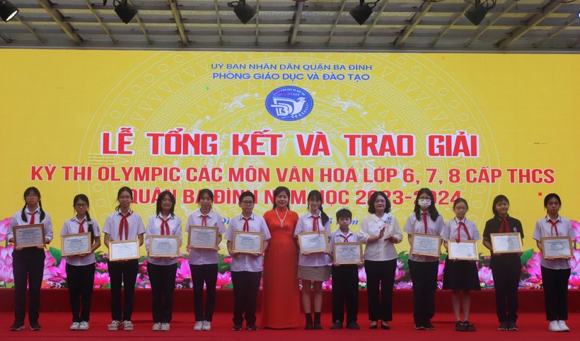 Nhà giáo Nguyễn Thanh Hà (áo đỏ) - Hiệu trưởng Trường THCS Phan Chu Trinh và cô Tô Thị Hải Yến - Hiệu trưởng trường THCS Giảng Võ trao thưởng cho các em học sinh.