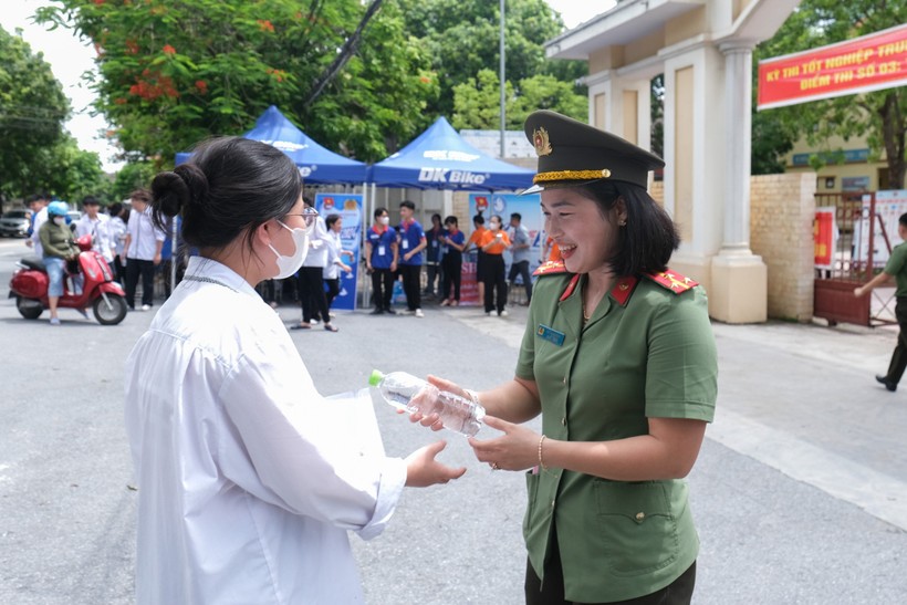Cán bộ công an tặng nước uống cho thí sinh điểm thi Trường THPT Hoàng Quốc Việt.