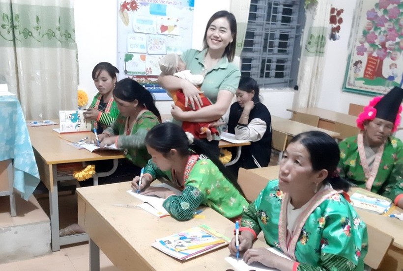 Cô Vừ Thị Pa, giáo viên Trường PTDTBT Tiểu học và THCS Tênh Phông bế con cho học viên học bài. Ảnh NVCC.