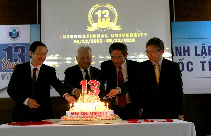 Đ/c Huỳnh Thành Đạt (trái) cùng đại diện lãnh đạo nhà trường cắt bánh sinh nhật lần thứ 13