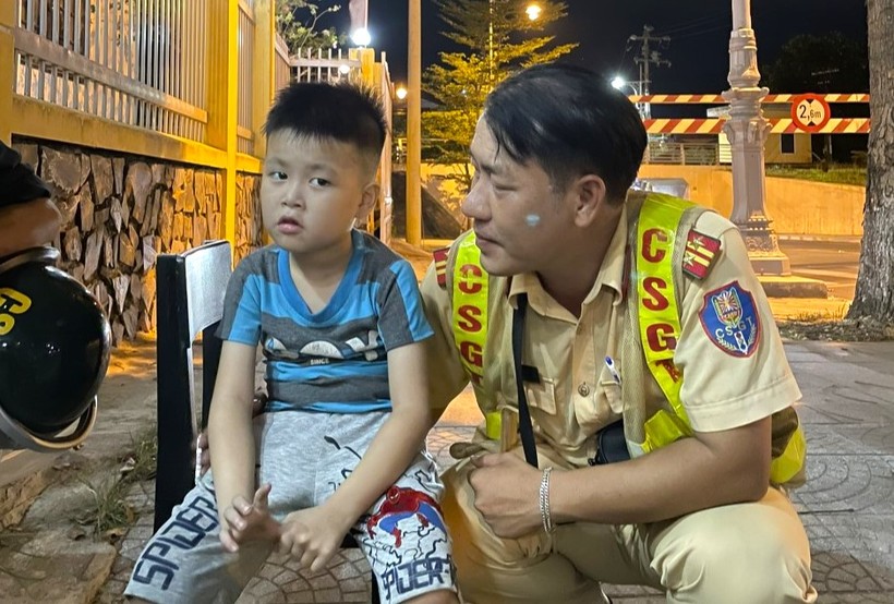 Trung tá Nguyễn Đình Xà hỏi thăm và cùng đồng đội hỗ trợ đưa cháu bé đi lạc về với gia đình. (Ảnh: CACC).