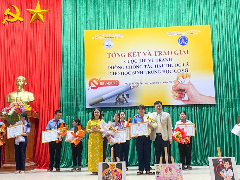 Đại diện Phòng GD&ĐT thị xã Hương Trà và Trung tâm kiểm soát bệnh tật tỉnh Thừa Thiên - Huế trao thưởng cho các em học sinh. (Ảnh: Hoàng Hải).