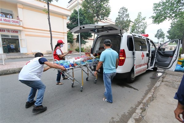 Các tình nguyện viên chuyển bệnh nhân lên chuyến xe 0 đồng.