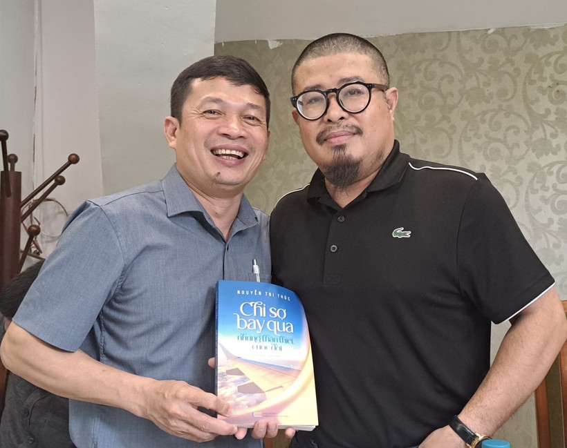 Nhà báo Nguyễn Tri Thức (trái) tặng sách tác giả. Ảnh: NVCC.