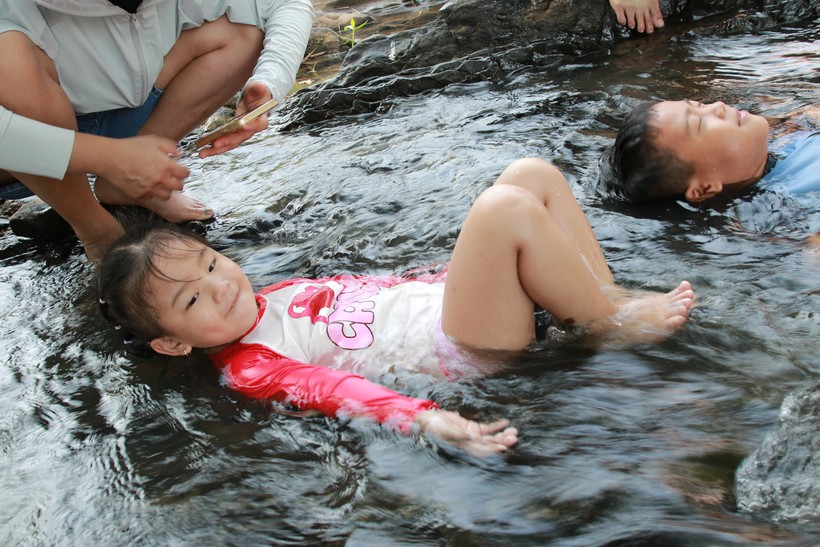 Những đứa trẻ, con cô Hoàng Khánh Linh, thả mình dưới dòng nước trong mát. Ảnh: TT