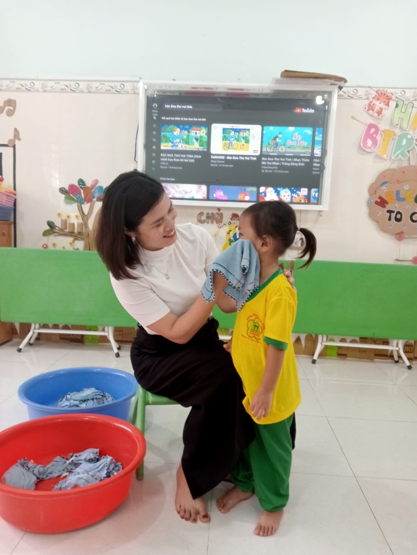 Cô Phen Eya – giáo viên Trường Mầm non Eatling (huyện Cư Jút, Đắk Nông) hướng dẫn trẻ sử dụng khăn mặt để giữ vệ sinh cá nhân trên lớp. Ảnh: TG