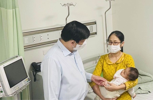 Bộ trưởng Bộ Y tế Nguyễn Thanh Long thăm, trò chuyện với gia đình cháu bé bị tiêm nhầm vắc xin Covid-19 đang theo dõi sức khoẻ tại Bệnh viện Saint Paul... Ảnh: T.Q.