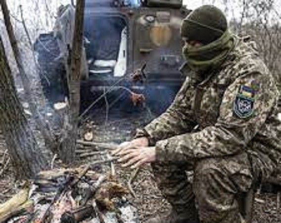 Một người lính Ukraine cố gắng giữ ấm trên tiền tuyến ở tỉnh Donetsk