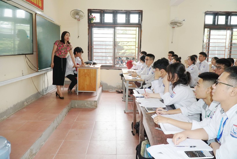 Cán bộ phụ trách tuyển sinh Trường THPT Thái Lão (huyện Hưng Nguyên, Nghệ An hướng dẫn học sinh khối 12 đăng ký thi tốt nghiệp THPT trực tuyến. Ảnh: Hồ Lài