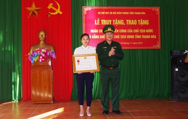 Chị Lương Thị Chon- vợ của liệt sĩ Vi Văn Nhất đón nhận Huân chương chiến công hạng Nhất do Chủ tịch nước truy tặng.