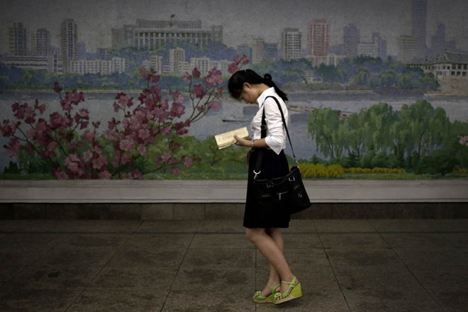 Một cô gái trong bộ trang phục gồm áo sáng màu, váy ngắn và giày cao gót tại một ga tàu điện ngầm ở Bình Nhưỡng. Ảnh: AP
