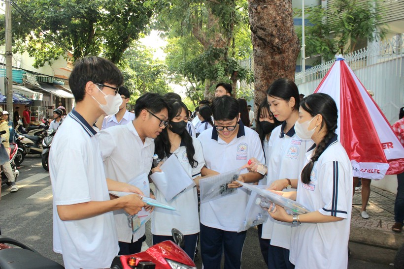 Một số thí sinh đến sớm tranh thủ trao đổi về đề thi môn Ngữ văn và phương pháp giải đề Toán nhanh tại điểm thi Trường THPT Đinh Tiên Hoàng.