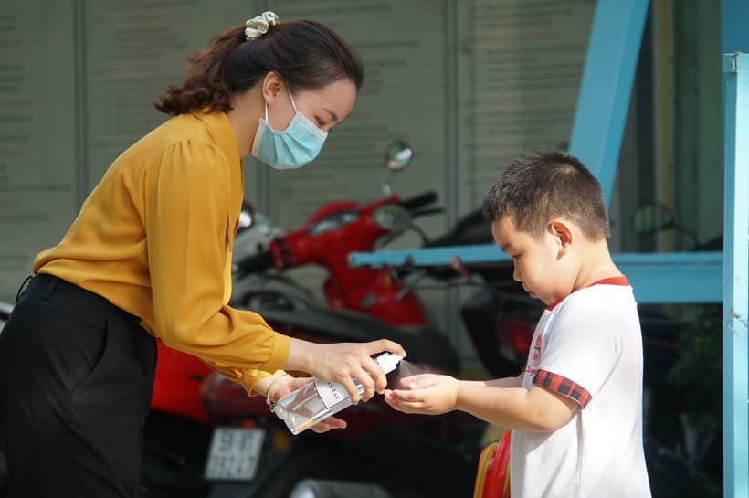Giáo viên Trường Mầm non Hoa Phượng Đỏ (quận Gò Vấp, TPHCM) giúp trẻ rửa tay sát khuẩn trước khi vào lớp học, tháng 5/2020. Ảnh: Mạnh Tùng