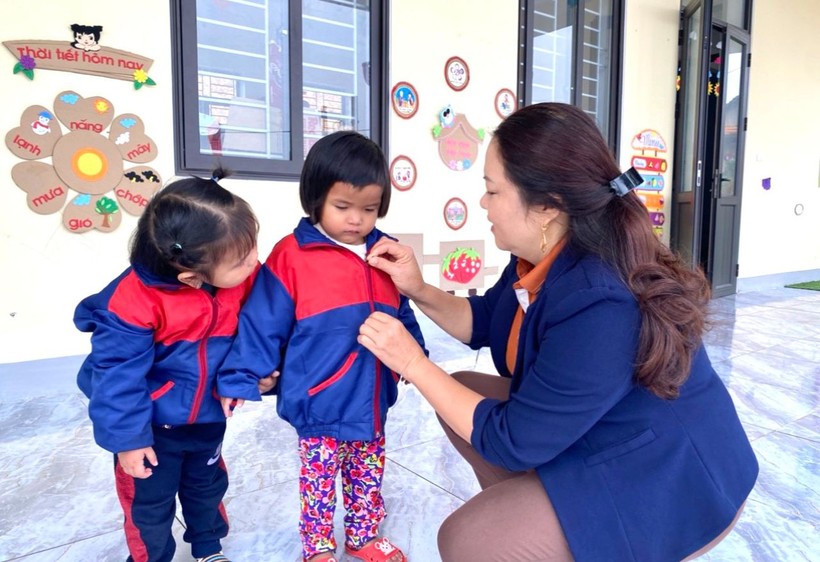 Giáo viên Trường Mầm non Hương Liên (Hương Khê, Hà Tĩnh) giúp trẻ mặc ấm khi đến lớp. Ảnh: Hồ Phương