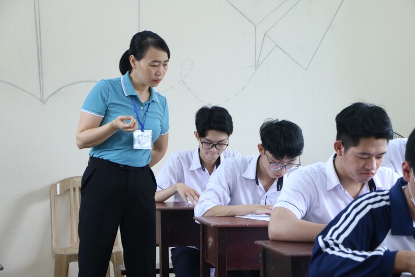 Cán bộ giám thị hướng dẫn thí sinh kiểm tra thông tin cá nhân trên thẻ dự thi tại Nam Định. Ảnh: TG