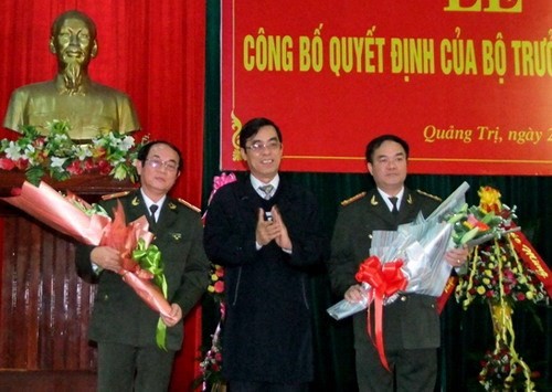 Chủ tịch UBND tỉnh Quảng Trị Nguyễn Đức Chính(giữa) tặng hoa cho thiếu tướng Lê Công Dung (trái) và đại tá Vũ Chiến Thắng trong buổi lễ công bố - Ảnh: Công an tỉnh Quảng Trị