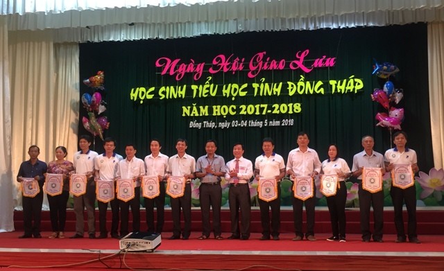 Ông Nguyễn Minh Tâm Phó Giám đốc Sở GD&ĐT và  Ông Võ Chí Hữu Phó Bí thư Đoàn TNCS HCM tặng cờ lưu niệm cho các đơn vị tại Lễ Khai mạc.