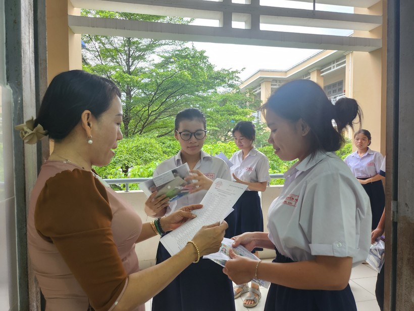 Cán bộ coi thi đọc tên thí sinh vào phòng thi tại điểm thi Trường THCS Nguyễn Trung Trực.