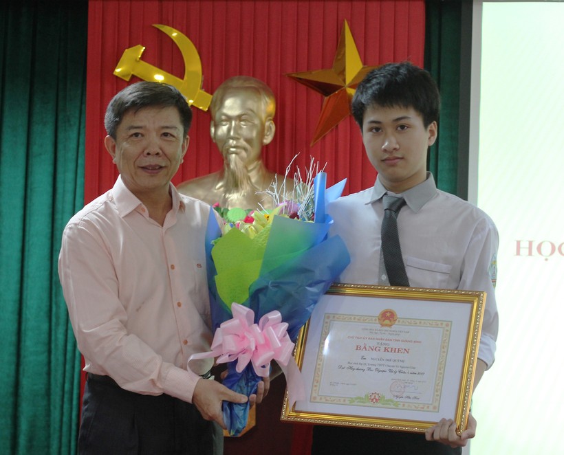 Ông Nguyễn Hữu Hoài - Chủ tịch UBND tỉnh Quảng Bình - trao bằng khen cho học sinh Nguyễn Thế Quỳnh đã xuất sắc giành HCB Olympic Vật lý châu Á năm 2017. 