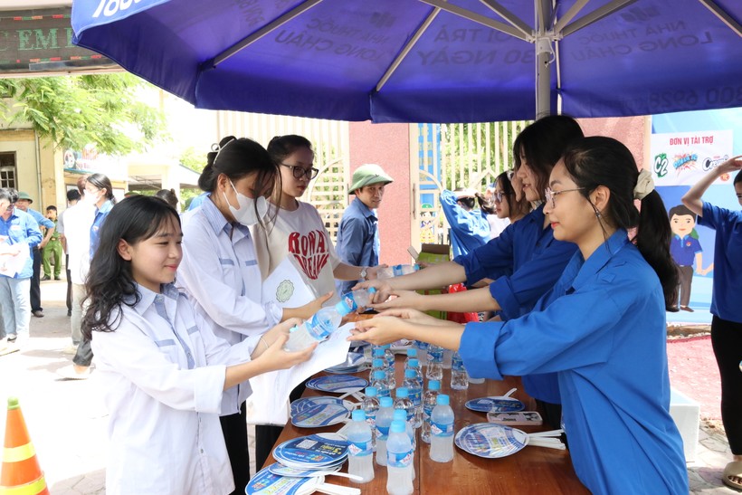 Thanh niên tình nguyện phát nước cho thí sinh tại điểm thi Trường THPT Hà Huy Tập. Ảnh: Phạm Tâm.