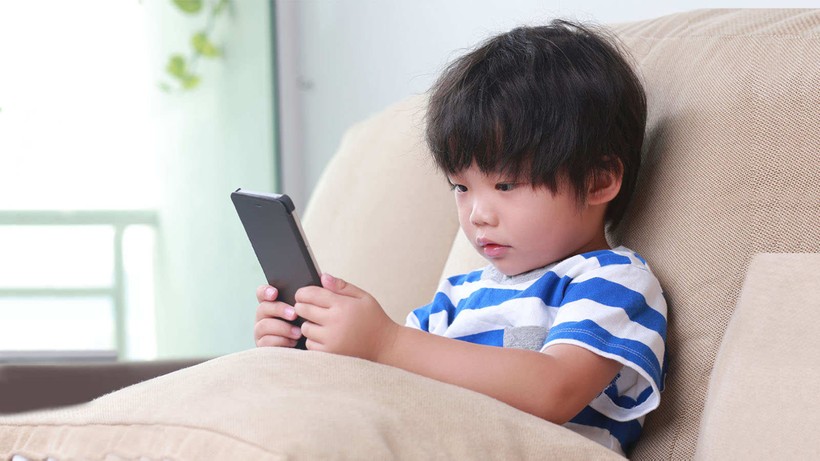 Một số trẻ có thể sử dụng điện thoại di động khi mới 8-9 tuổi. (Ảnh: ITN).