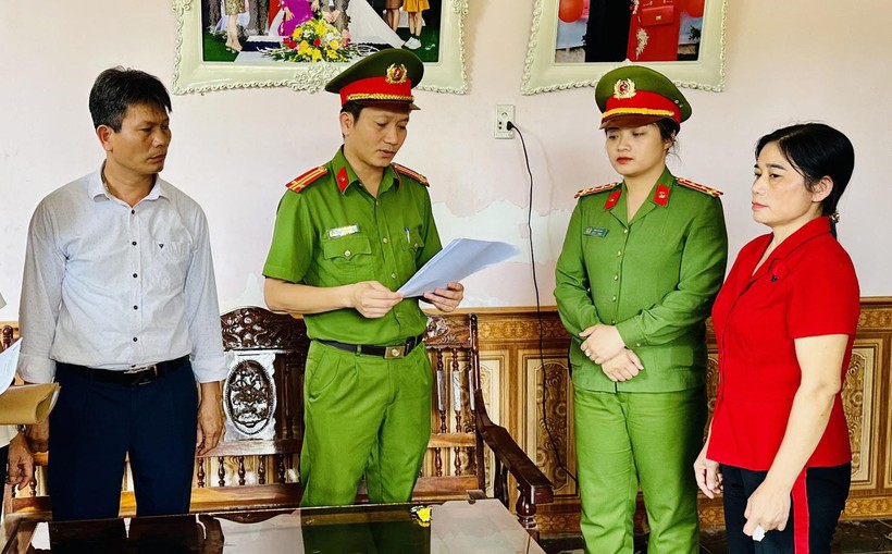 Cảnh sát đọc lệnh bắt tạm giam Nguyễn Thị Minh (áo đỏ). (Ảnh: CATH).