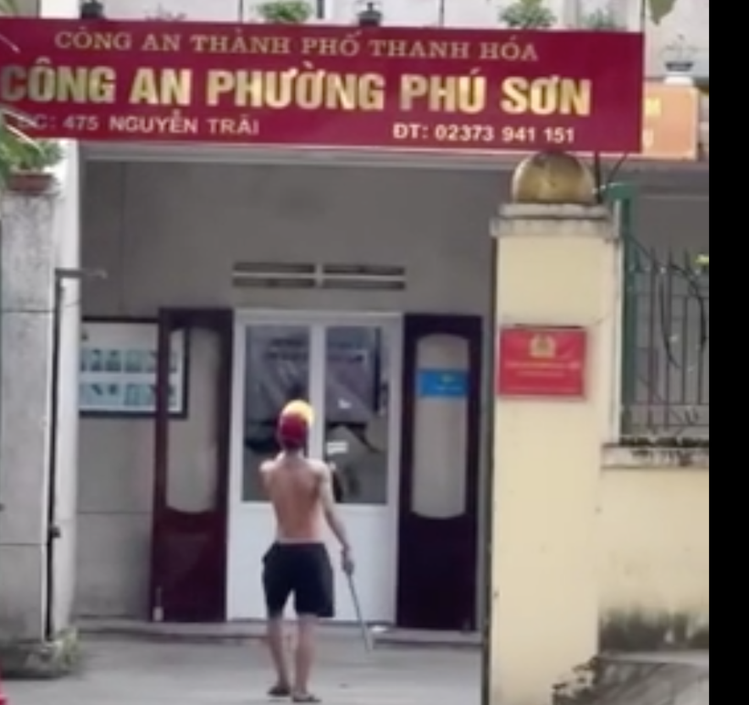 Nam thanh niên hùng hổ cầm gậy sắt xông vào trụ sở công an phường Phú Sơn. (Ảnh: cắt từ clip)