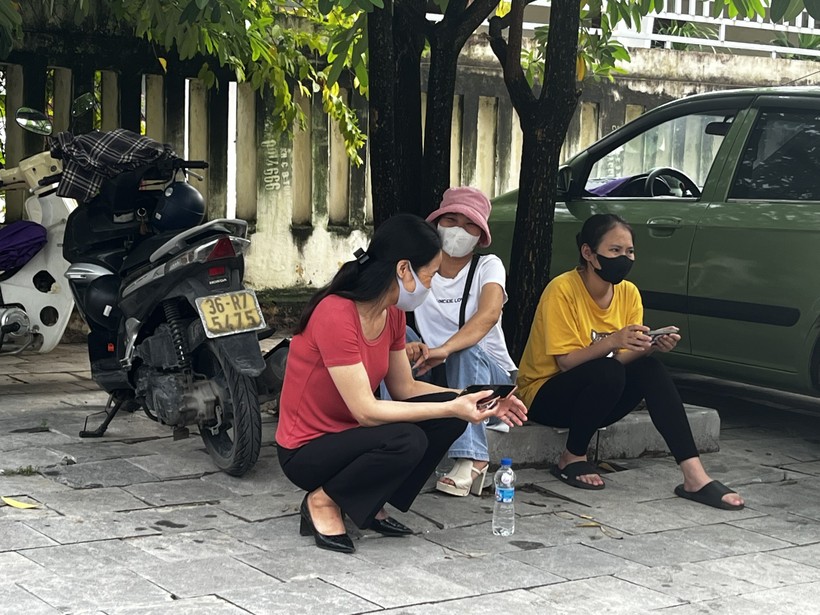 Chờ con ở điểm thi Trường THPT chuyên Lam Sơn, chị Nguyễn Thị Hoà (thị trấn Bút Sơn, huyện Hoằng Hoá) cùng hai phụ huynh khác đang tranh thủ trao đổi bên ngoài cổng trường thi.