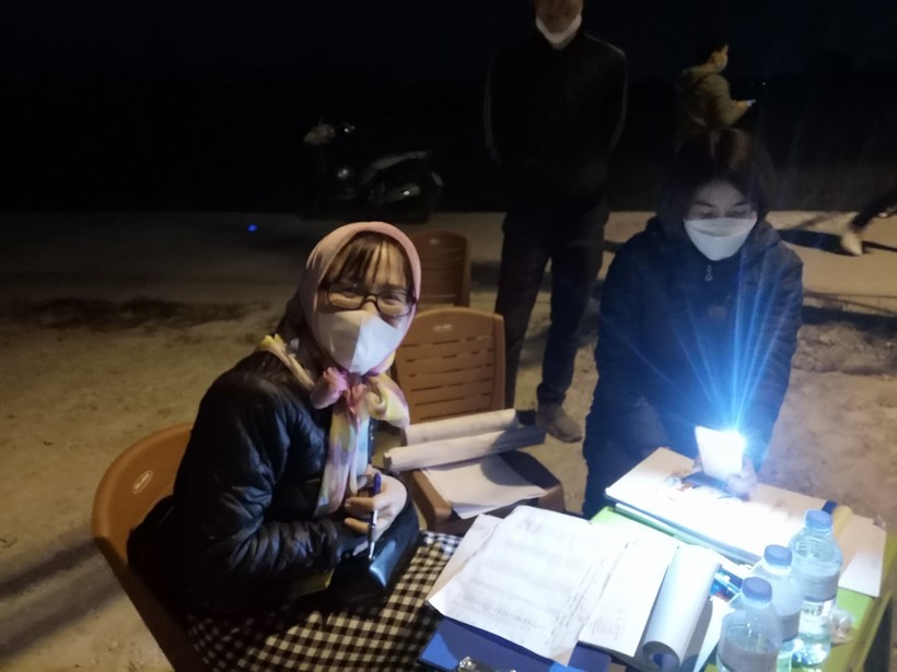 Nhân viên nhà đất soi đèn viết hợp đồng giao dịch đặt cọc đất trong đêm ngày 20/12. 